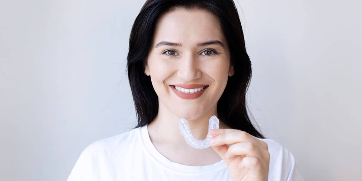 person putting in custom oral appliance